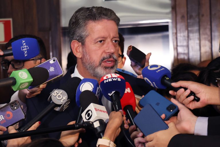 Arthur Lira está cercado de microfones