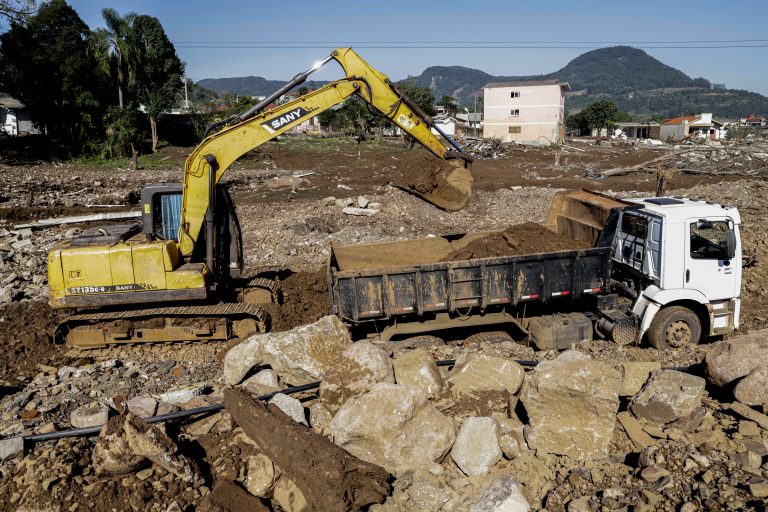 Retroescavadeira faz limpeza em Roca Sales em frente a casas destruídas após enchente