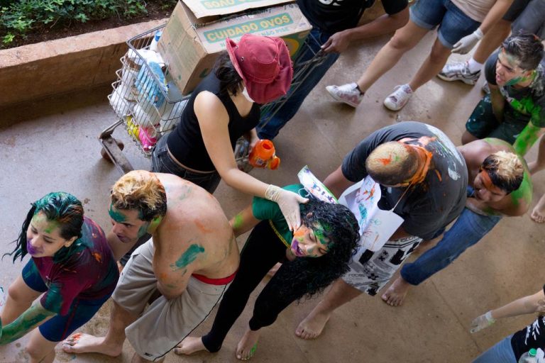 Calouros de universidade são pintados de tinta por alunos veteranos