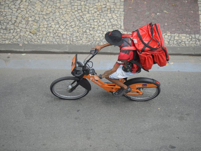 Trabalhador de entrega por aplicativo percorre ruas de bicicleta no Rio de Janeiro