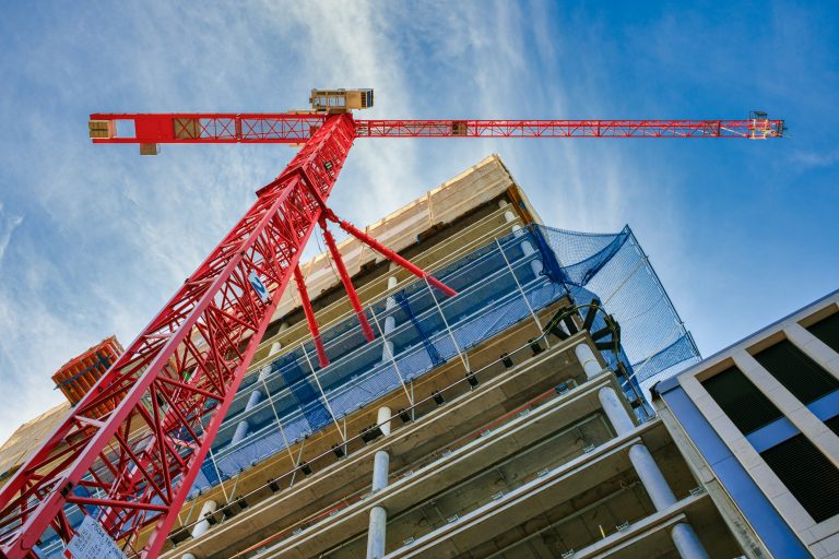 Um guindaaste vermelho na frente de um prédio em obras