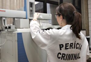 Perita criminal analisa prova em laboratório