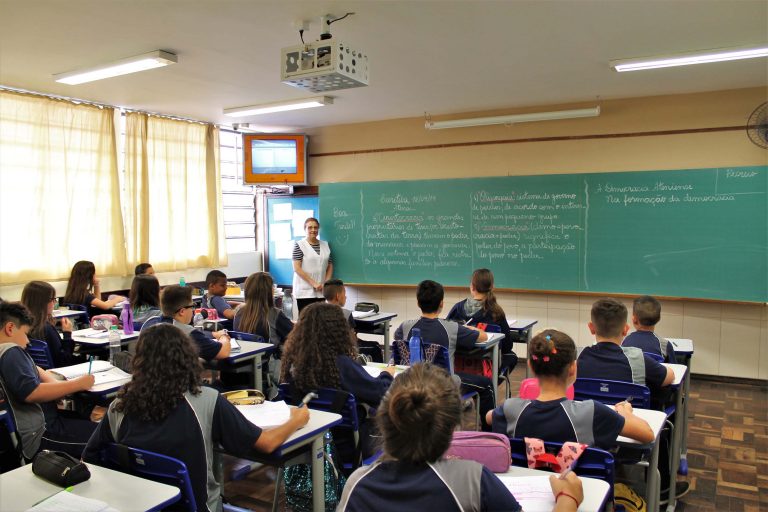 Professora e alunos em sala durante aula