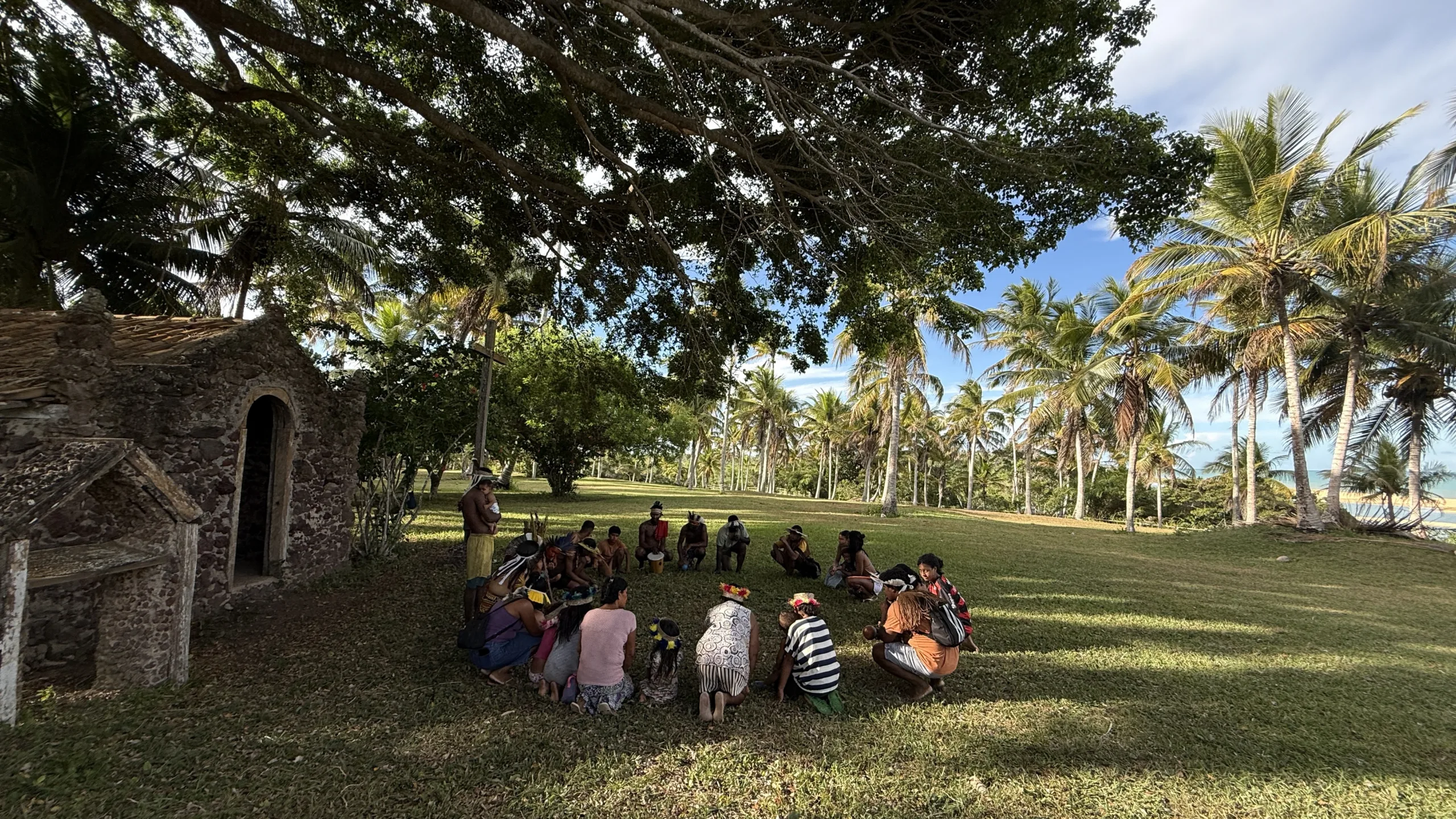 Indígenas Pataxó realizam o Awê, ritual tradicional de oração, em frente à capela erguida na Fazenda Barra do Cahy durante as comemorações dos 500 anos da chegada portuguesa. Ao fundo, o mar da praia onde teria ocorrido o primeiro contato entre europeus e povos originários.